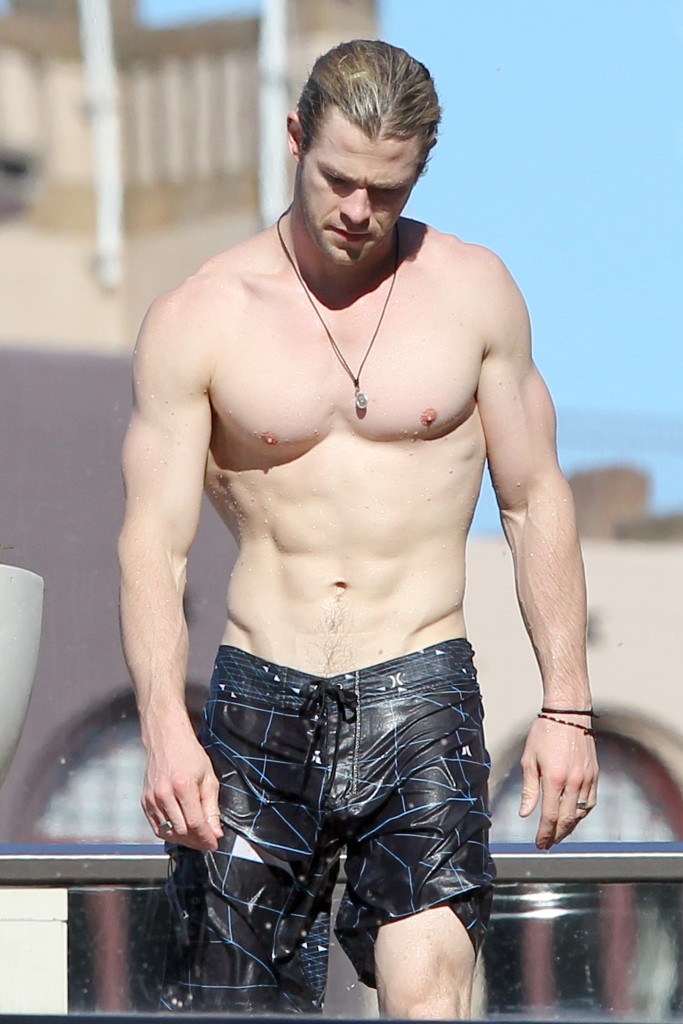 Chris Hemsworth shows off his ripped body as he chills by his hotel pool